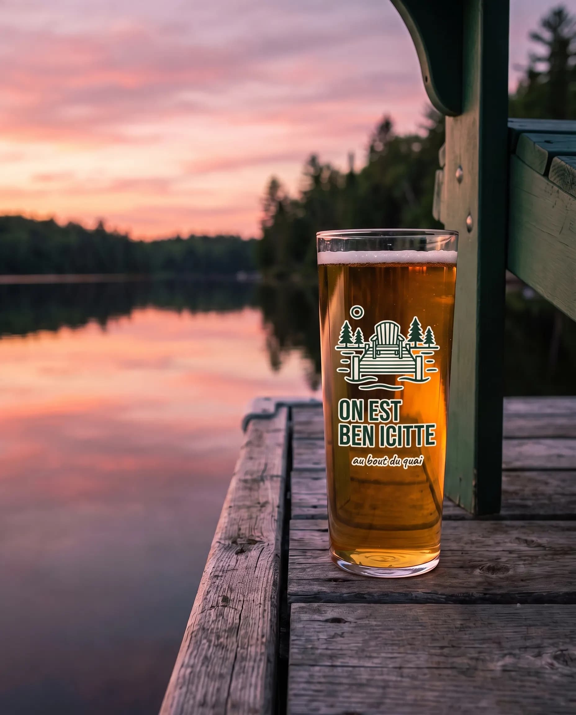 Un verre imprimé « On est ben icitte » au bout du quai au coucher du soleil